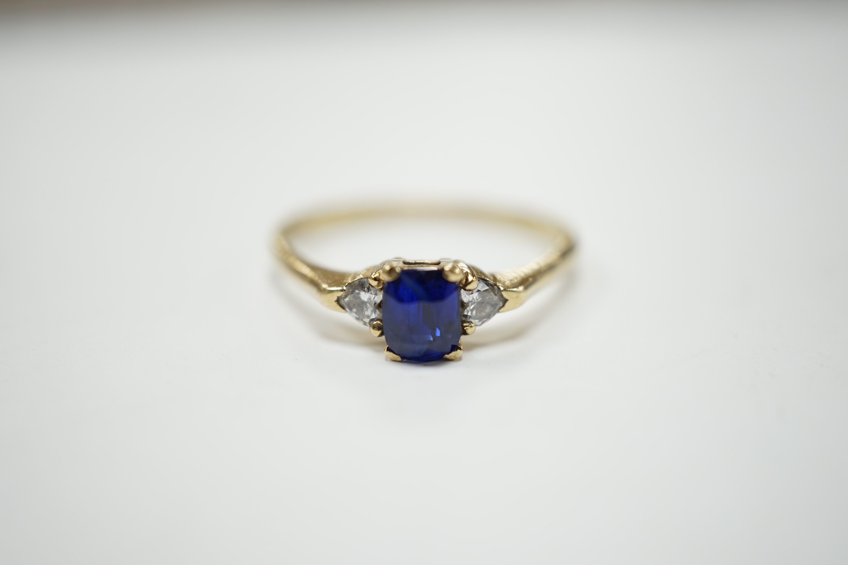 A yellow metal and single stone oval cut sapphire set ring, with two stone heart shaped diamond set shoulders, size U/V, gross weight 2.4 grams.